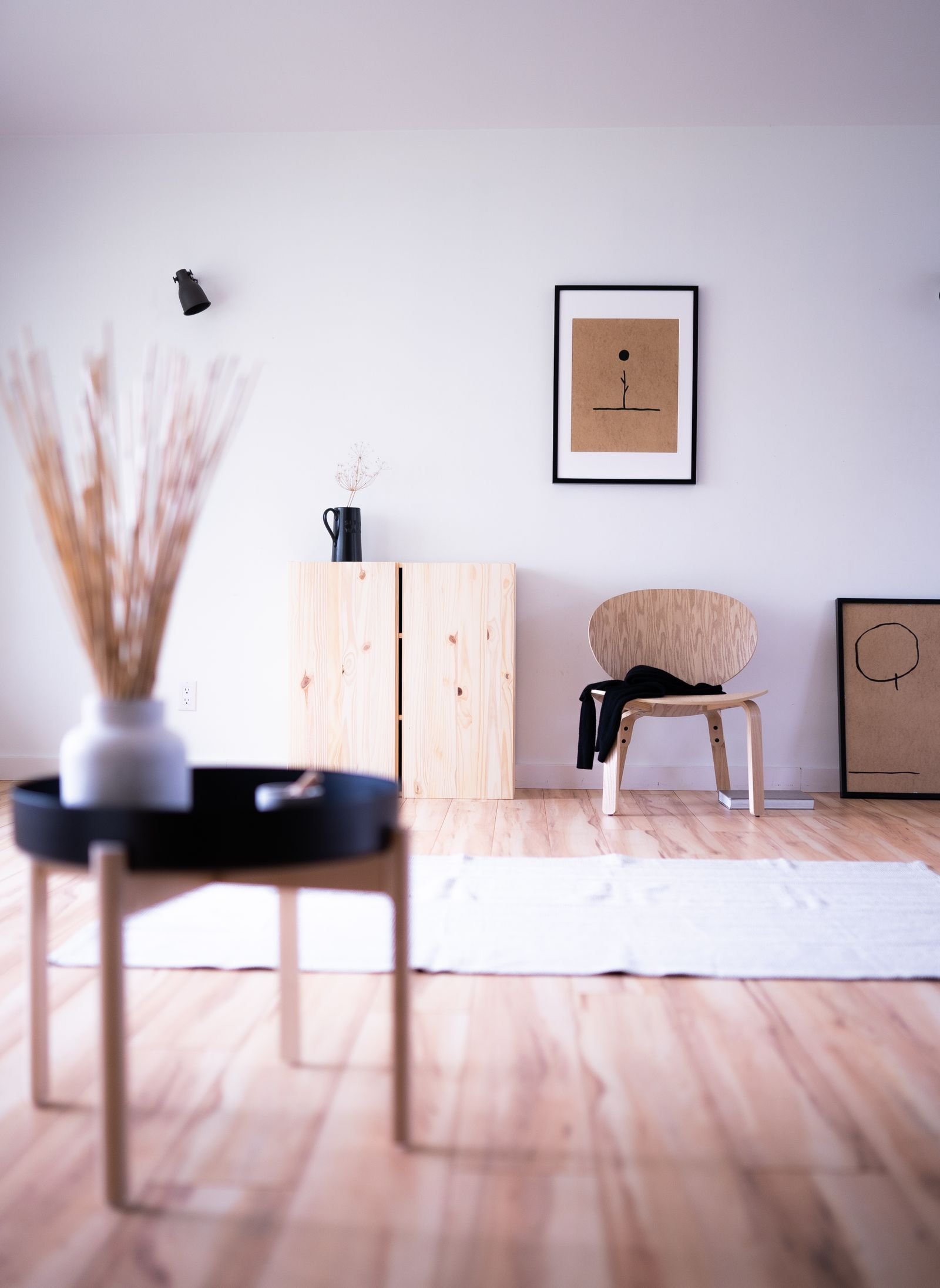Sala minimalista e arejada em estilo japandi, com madeira clara, poucos objetos e muita luz